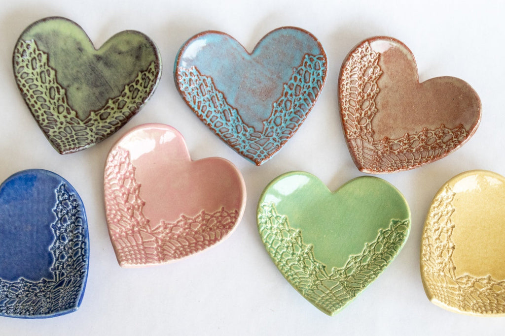 Heart-shaped ring dish set showing green, blue, pink, copper, and yellow glazes with texture