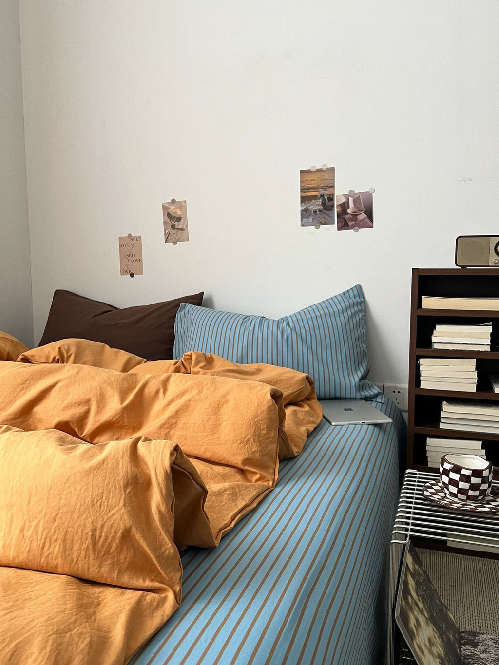 Orange bedding set on blue striped sheets with duvet and two accent pillows