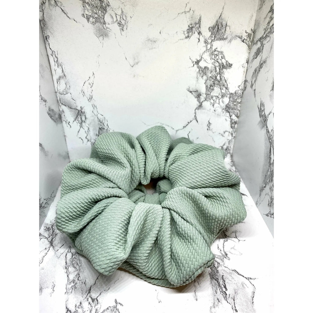 Sage green fabric scrunchie with thick gathered center and layered loops