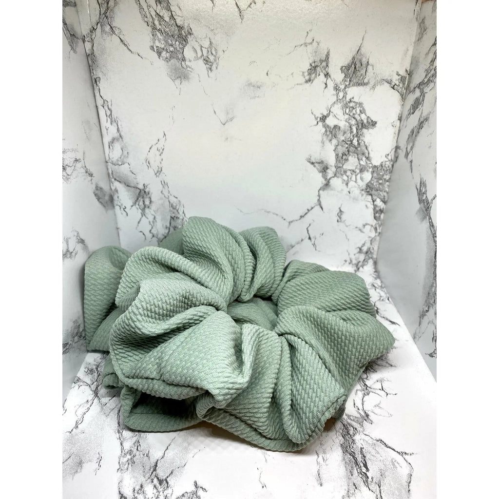 Sage green scrunchie with large bow-like knot and stitched gathers