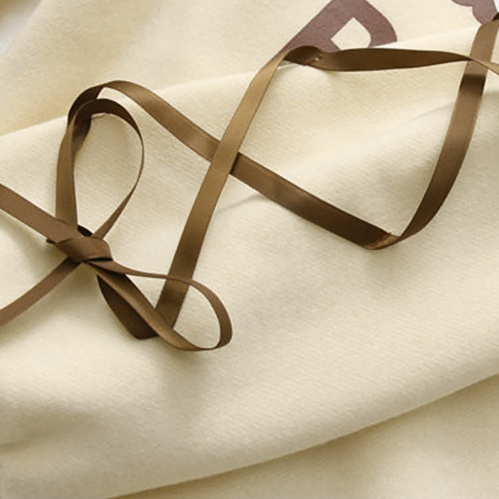 Cream hoodie fabric with brown ribbon trim and bow ties along the seam
