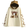 Front view of women's light yellow bear graphic pullover hoodie with brown bear hood