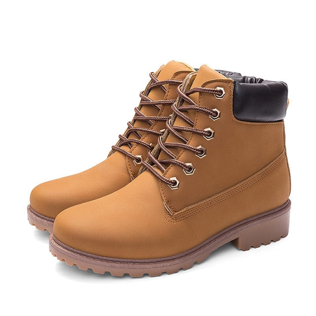 Tan plush ankle boots with black padded collar and lace-up front