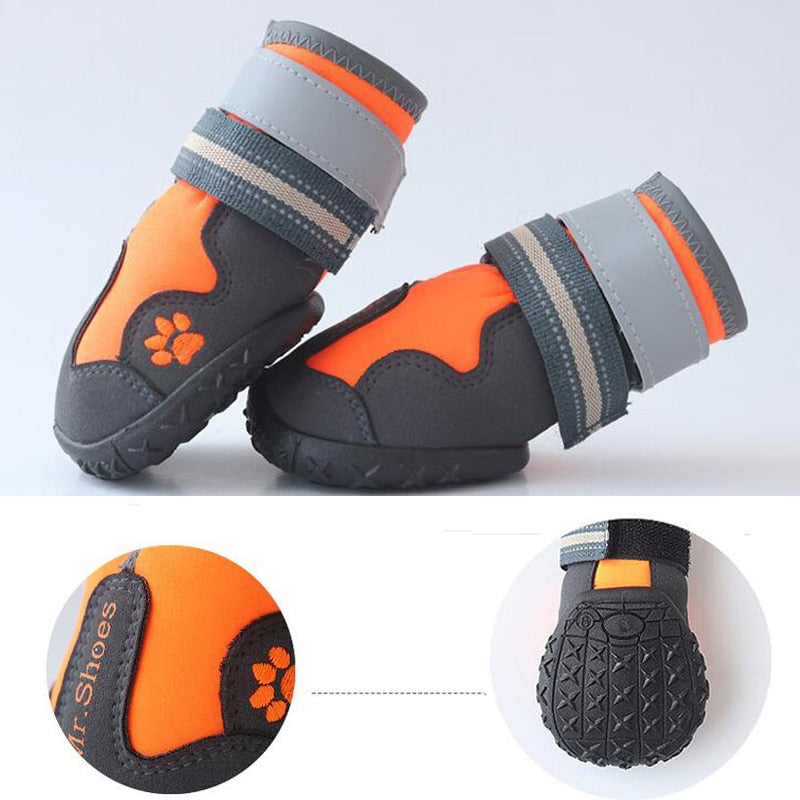 Orange and black waterproof dog boots with inset outsole texture and paw emblem