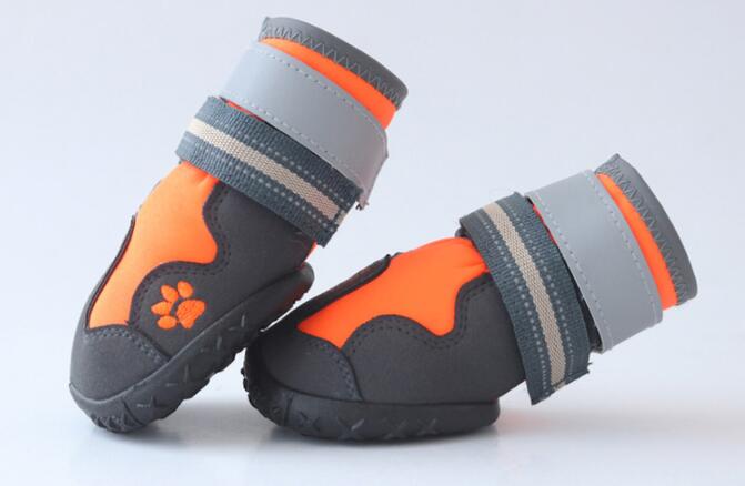 Pair of orange and black waterproof dog boots with gray reflective-style straps