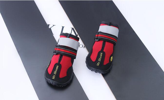Red waterproof dog boots with white cuffs, black trim, and double hook-and-loop