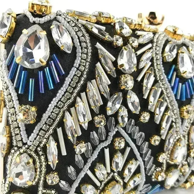 Close-up of black rhinestone clutch with crystal drops, blue beading, gold accents
