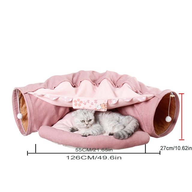 Collapsible cat tunnel tube with removable cushion, pink fabric, cat lying inside