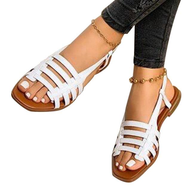 White strappy flat sandals with open toe, ankle slingback detail