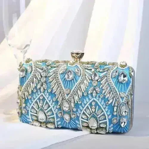 Blue rhinestone minaudiere clutch with intricate silver filigree and gem-like accents