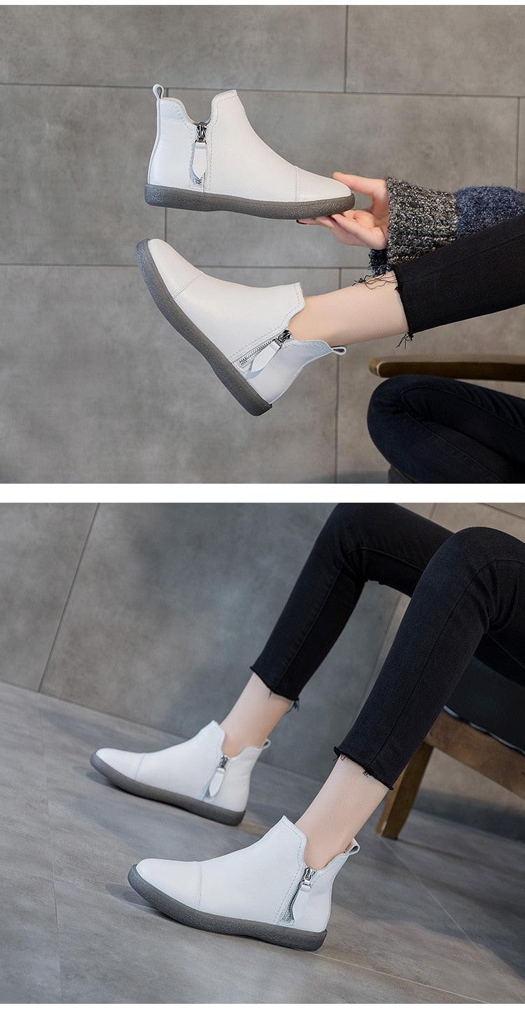 White fur-lined ankle boots with side zipper detail and flat gray sole