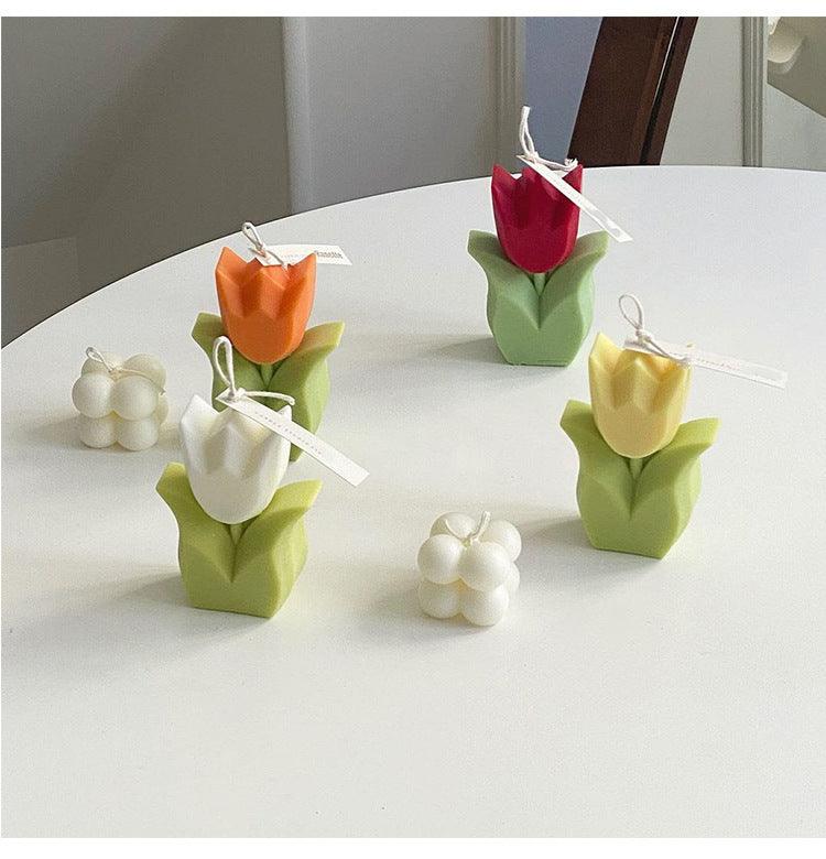 Assorted handmade tulip flower-shaped candles with hanging tags, in pastel colors