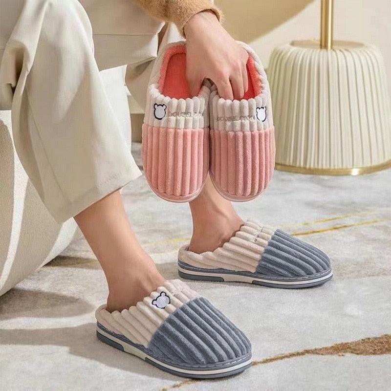 Pink and gray cord slippers with bear patch, worn on flat cushioned soles