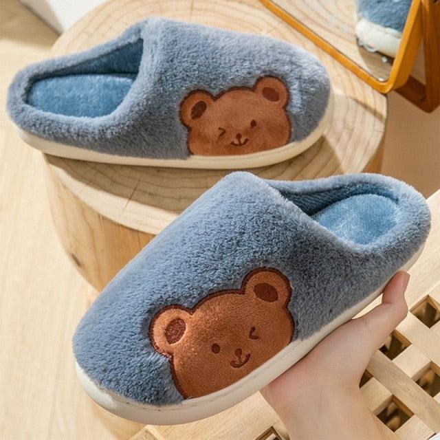 Fuzzy blue house slipper with bear patch and cushioned indoor sole