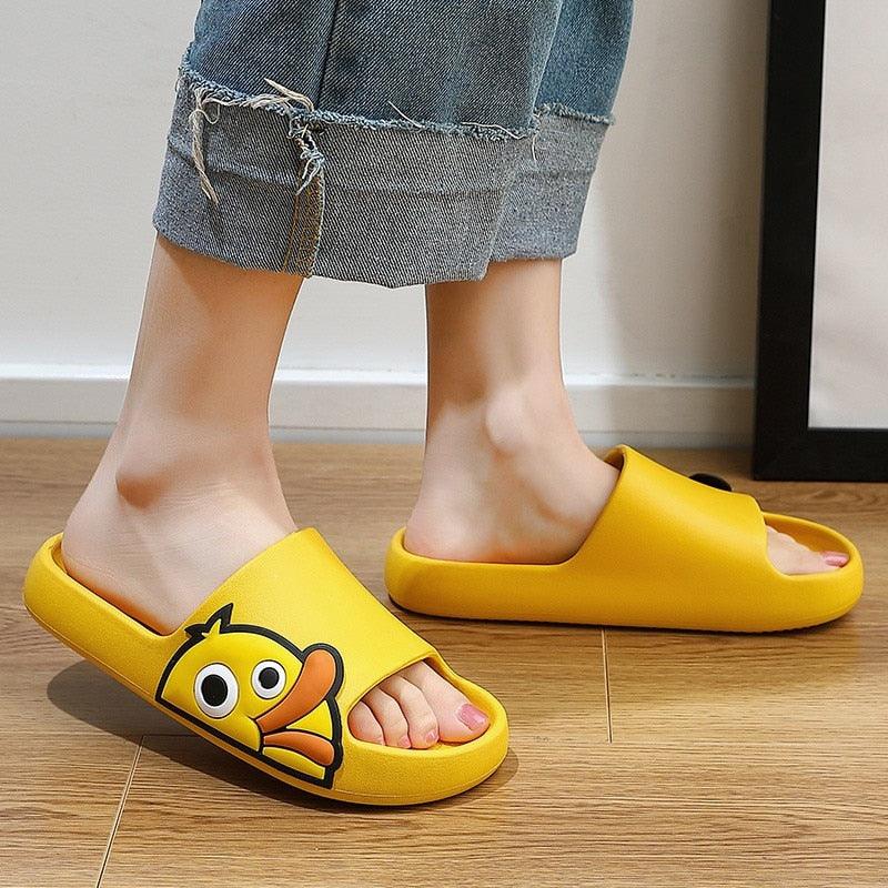 Yellow open-toe slip-on slides with cartoon face and cushioned, fuzzy lining.