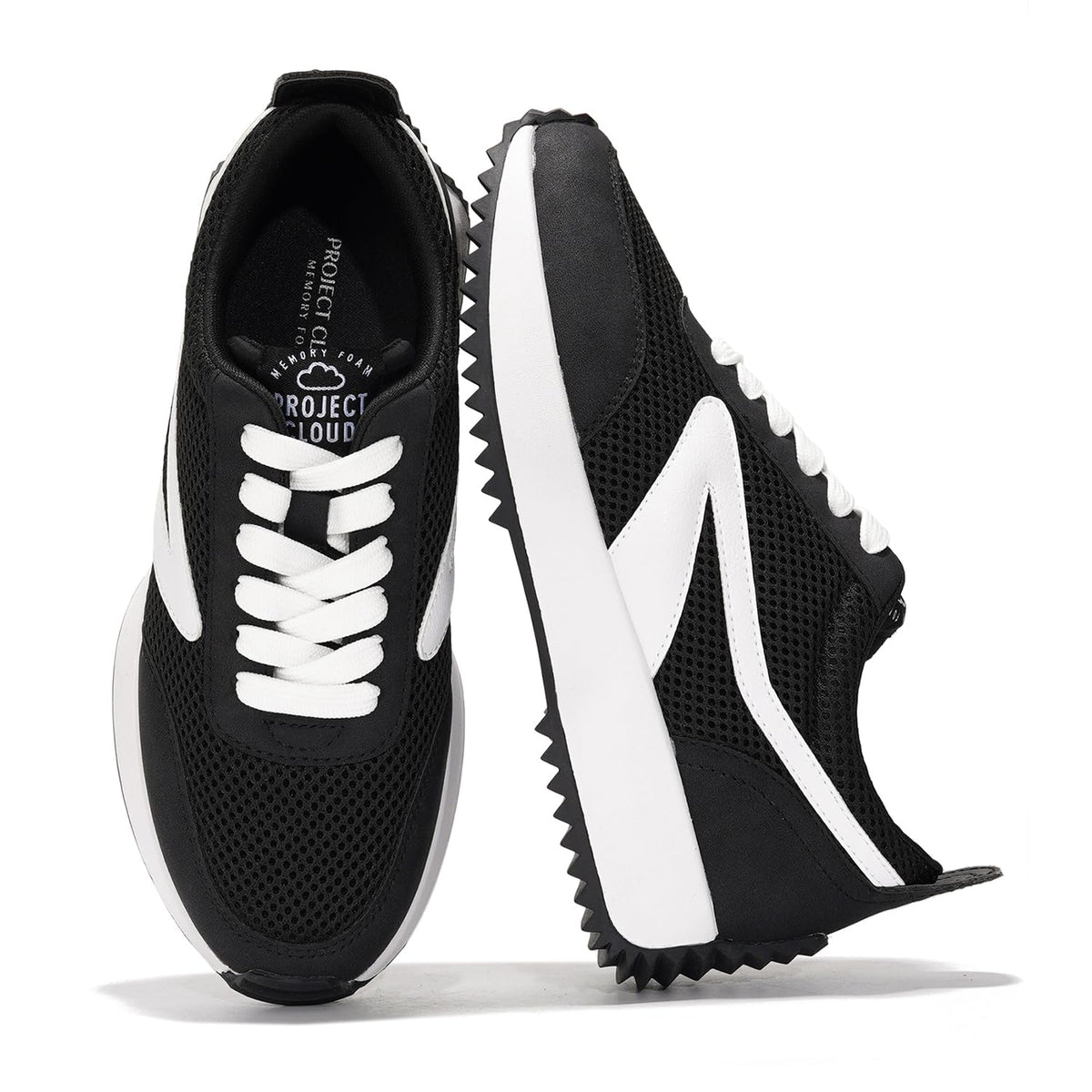 Black and white lace-up sneakers with perforated uppers and chunky tread wedge sole
