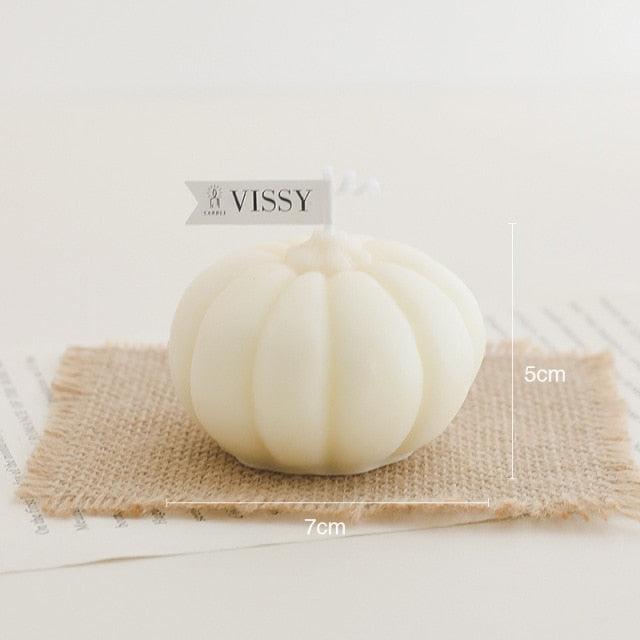 Ivory pumpkin-shaped candle on burlap square with VISSY tag