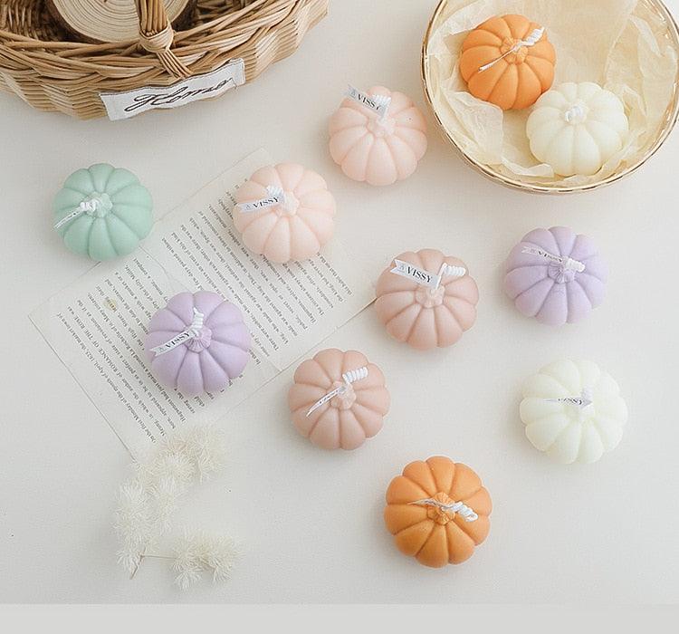 Assorted pumpkin-shaped aromatherapy candles in pastel lavender, mint, peach, and pink