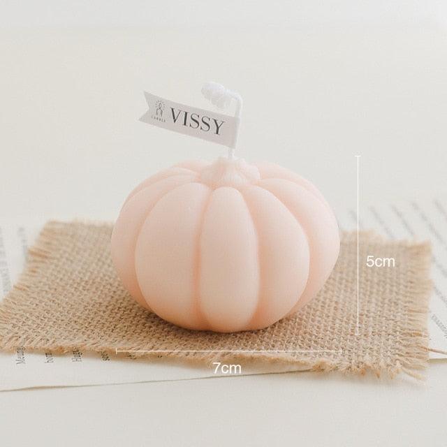 Pink pumpkin-shaped candle on burlap with VISSY label