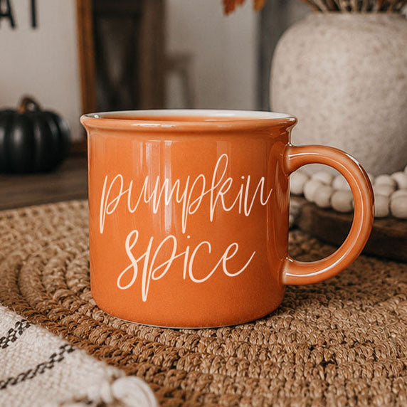 Orange ceramic mug with white script lettering and side handle
