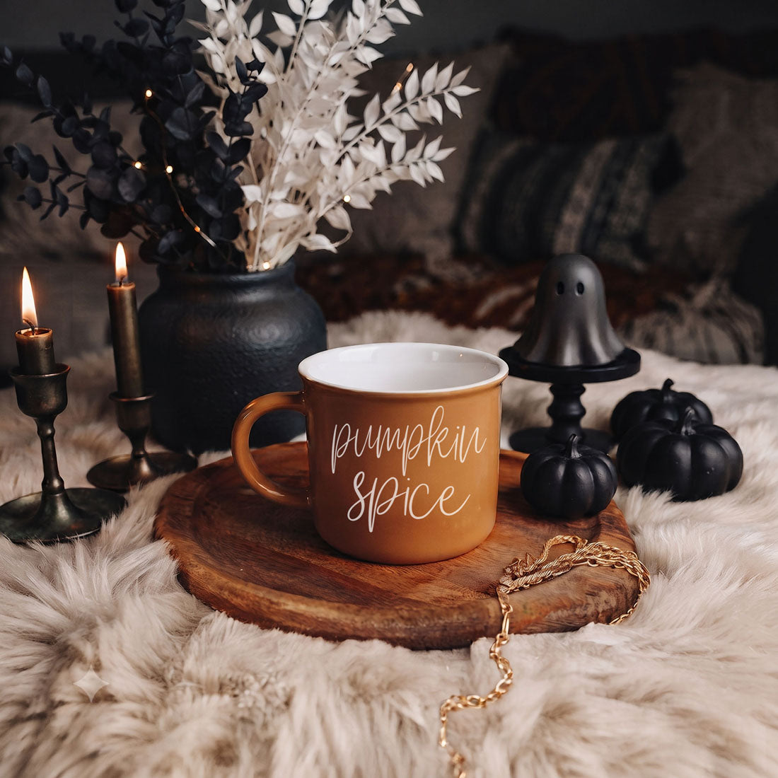 Orange mug with “Pumpkin Spice” script text on round wooden base