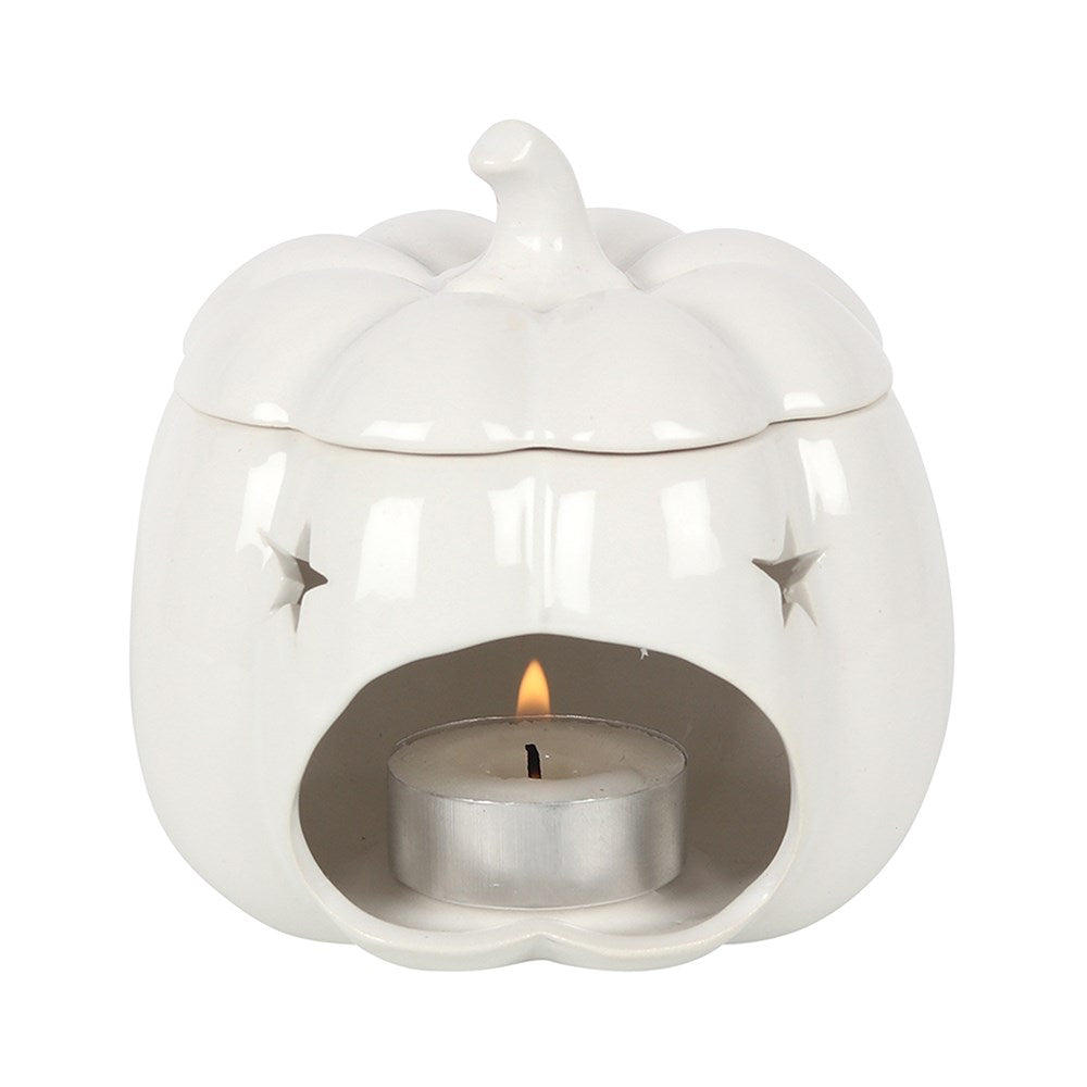 White ceramic pumpkin oil burner with star details and lit tealight in opening