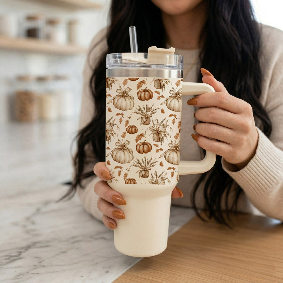 40oz tumbler with handle, straw, and pumpkin floral pattern held in both hands
