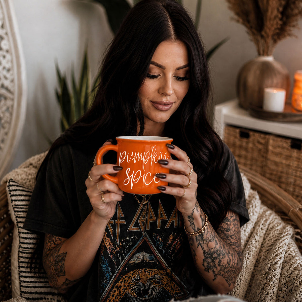 Orange mug with “Pumpkin Spice” script text held in front of a person