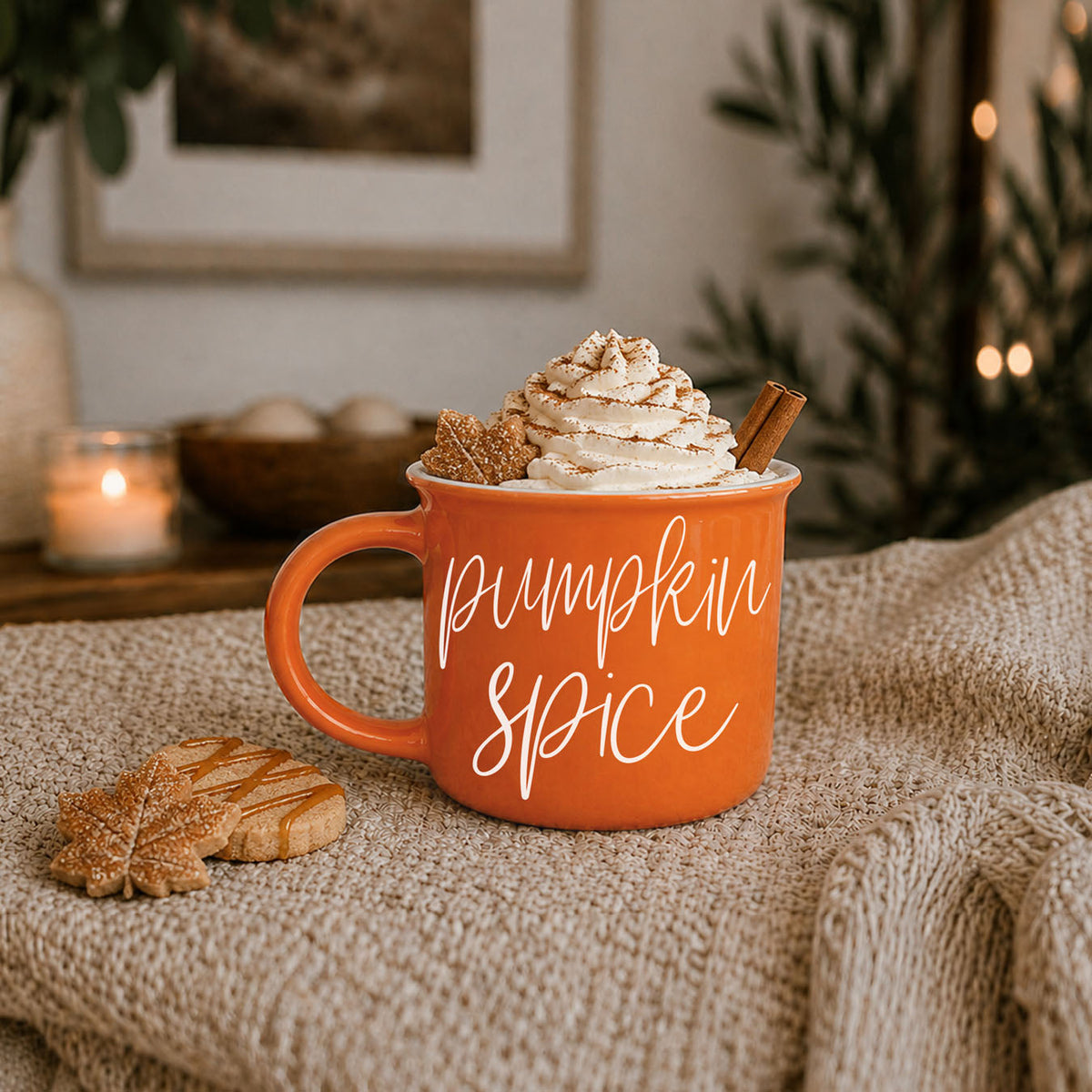Orange ceramic mug filled with whipped topping and white “pumpkin spice” script