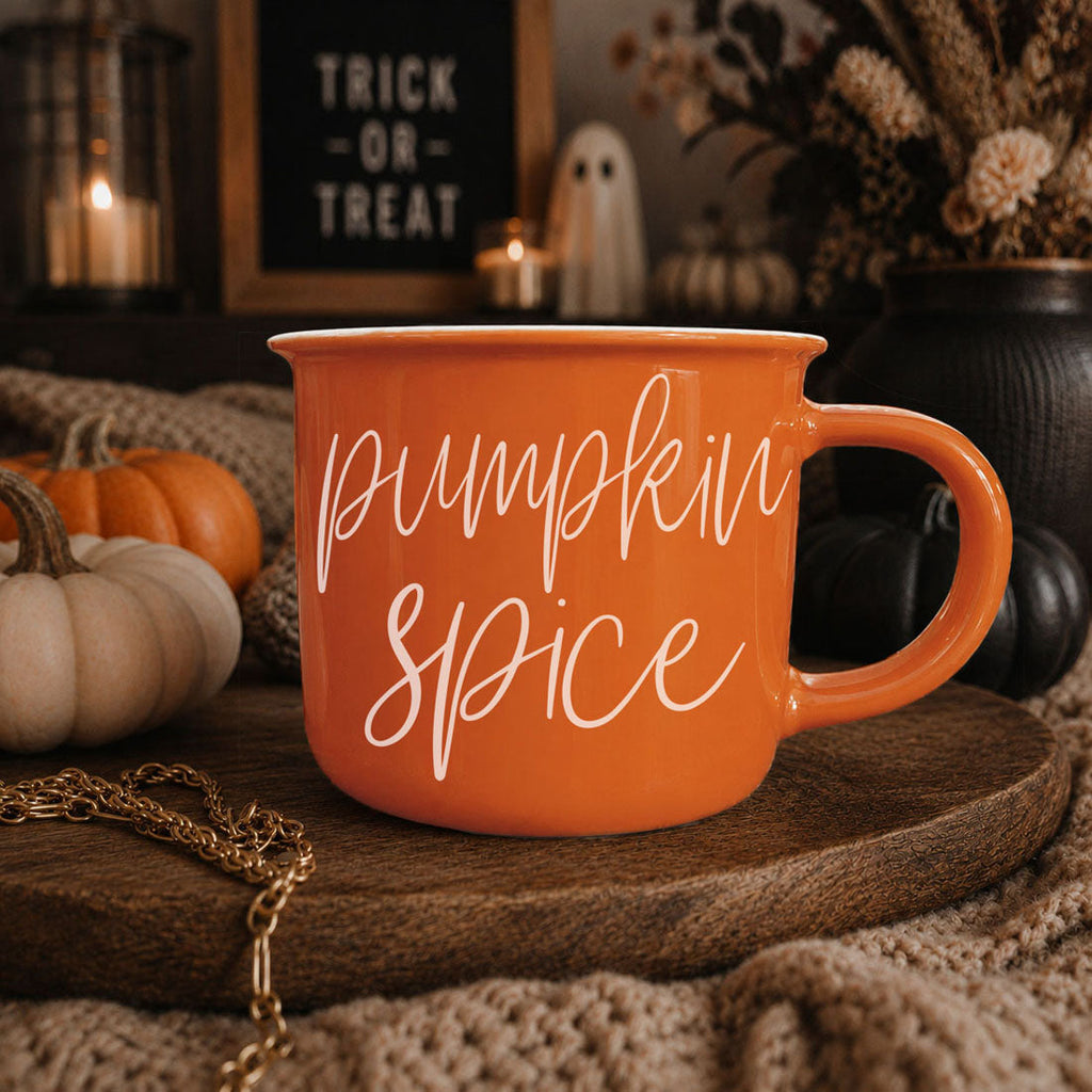 Orange mug with “Pumpkin Spice” script text on round wooden slab
