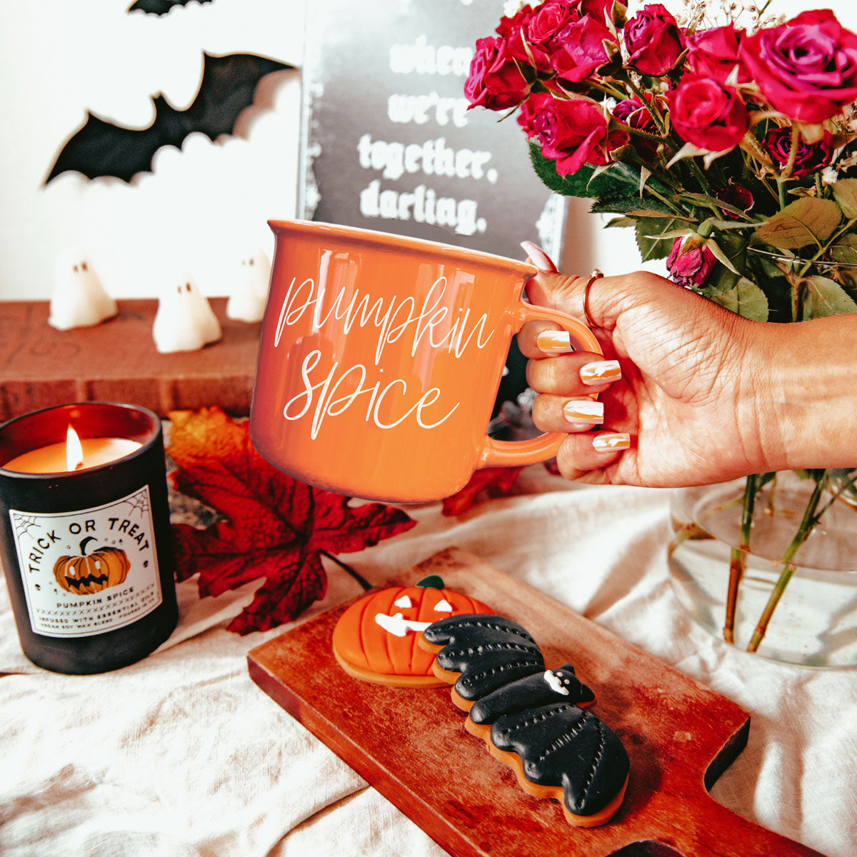 Orange mug with handle held in hand, Pumpkin Spice script on front