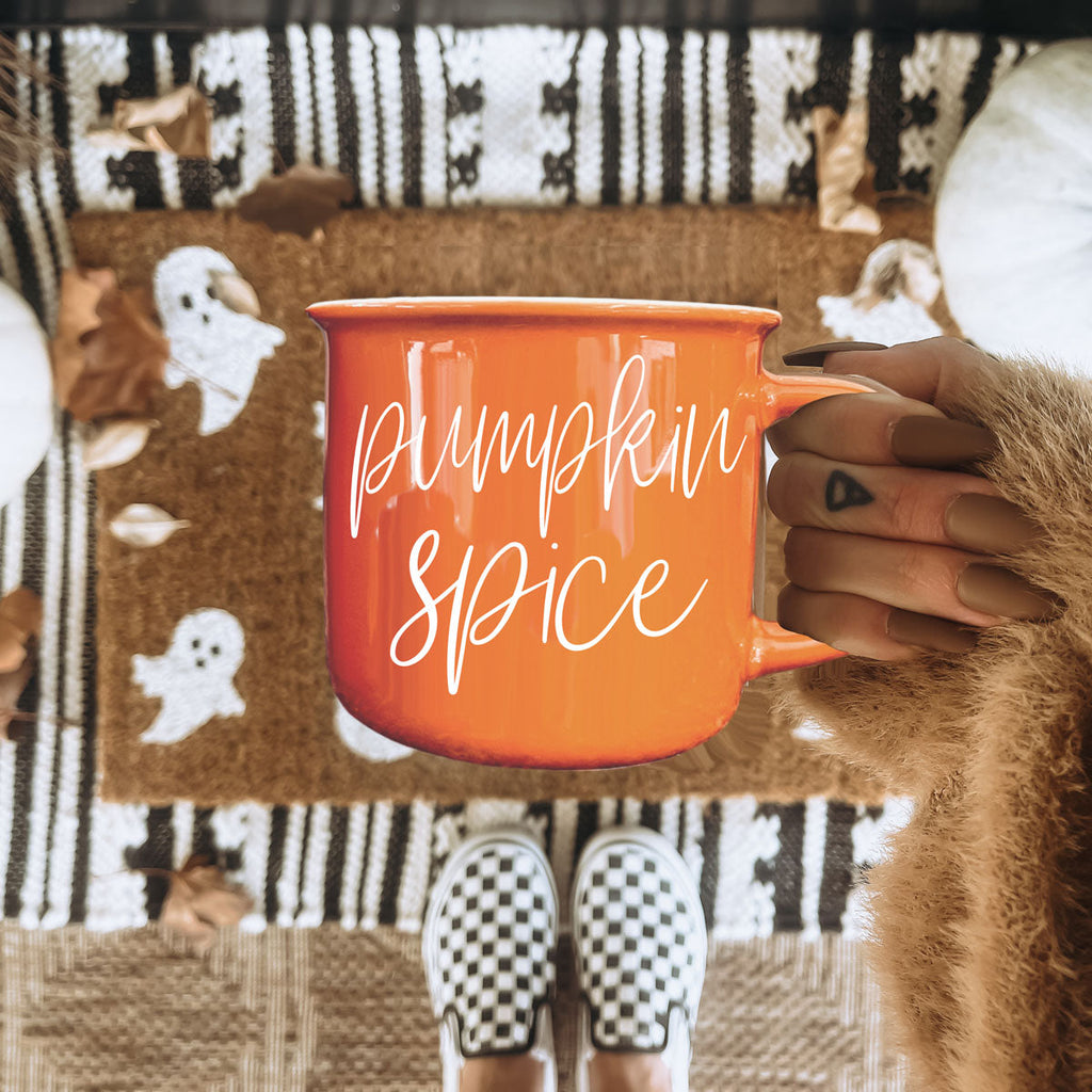 Orange ceramic mug with 'Pumpkin Spice' lettering, held by hand