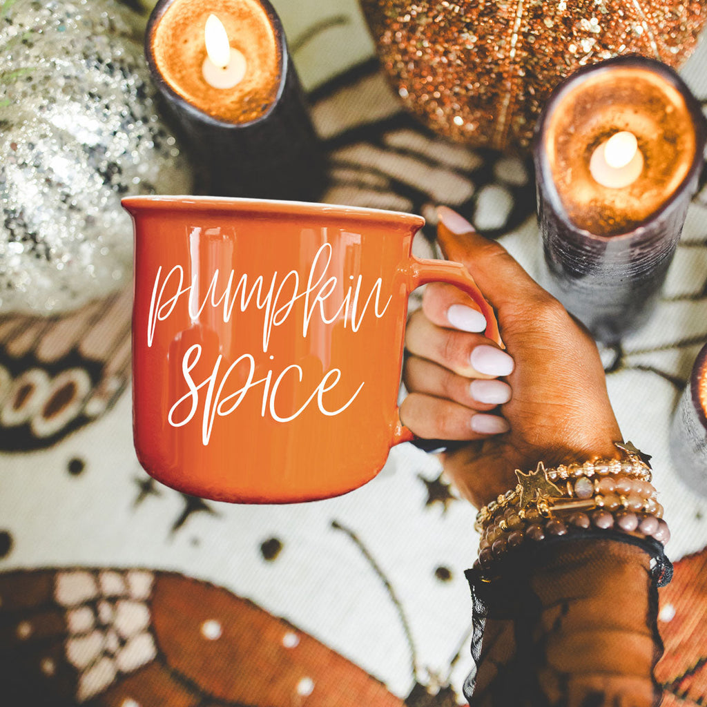 Orange ceramic mug with handle and Pumpkin Spice script lettering on front