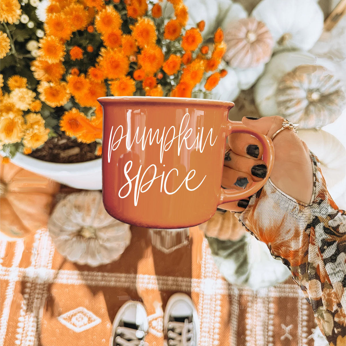 Orange mug with white cursive text for pumpkin spice, rounded lip and handle