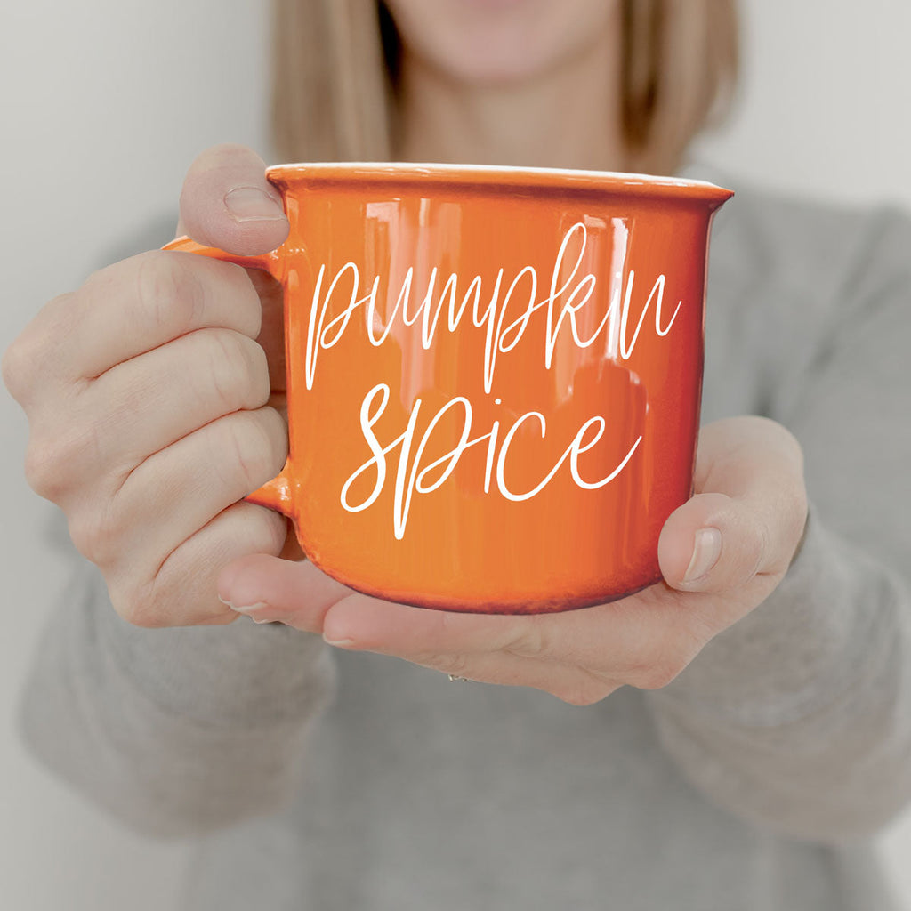 Close-up of orange mug with “Pumpkin Spice” script text and rounded rim