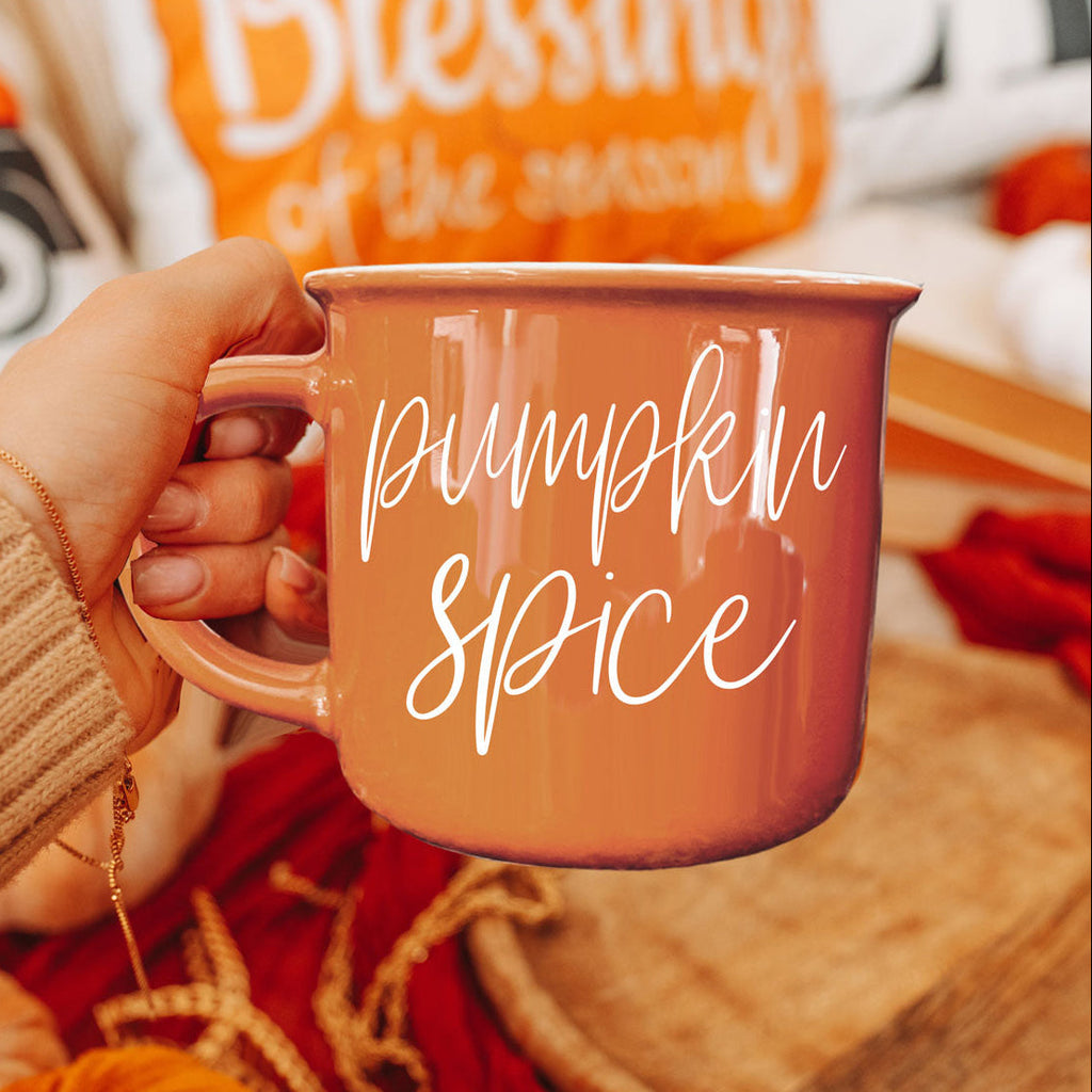 Close-up of orange mug with handle, Pumpkin Spice script lettering on front