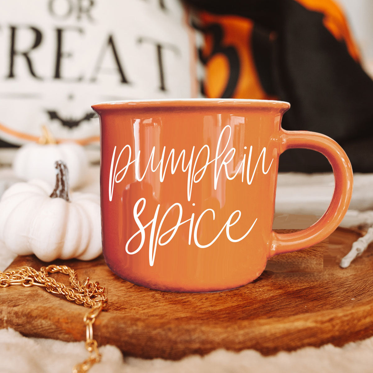 Orange ceramic mug with white “pumpkin spice” script, round handle close-up