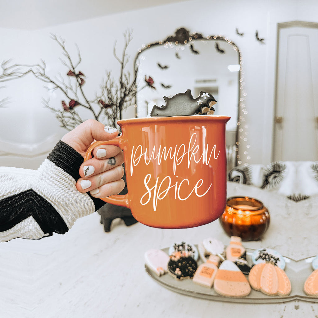 Orange ceramic mug with 'Pumpkin Spice' lettering, held in hand