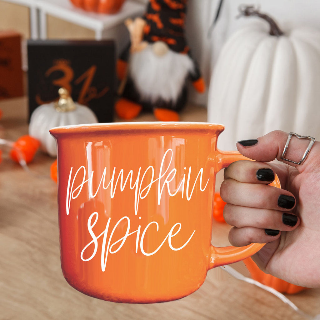 Orange ceramic mug with 'Pumpkin Spice' print, hand gripping handle