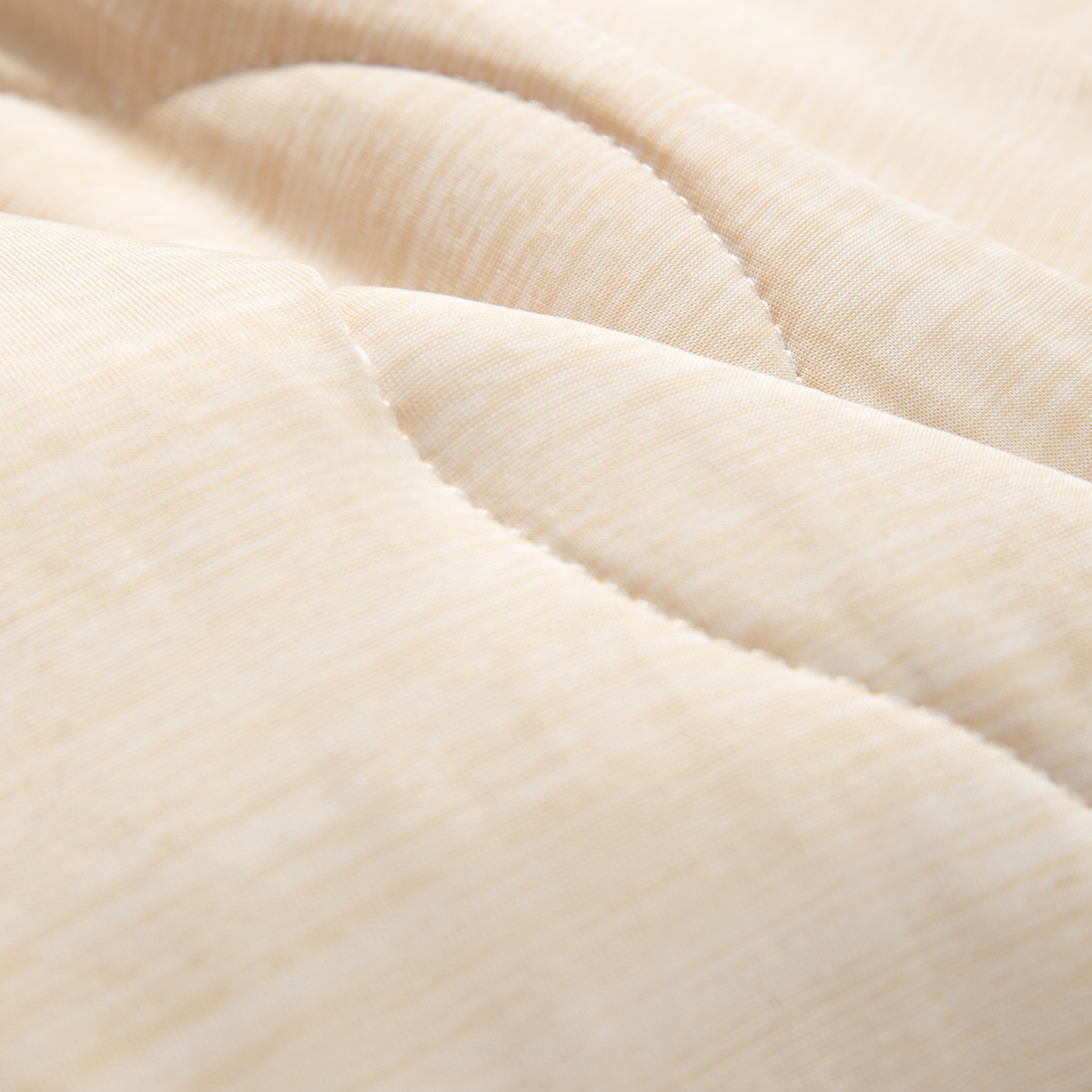 Close-up of light arctic sand blanket fabric with stitched quilted wave texture
