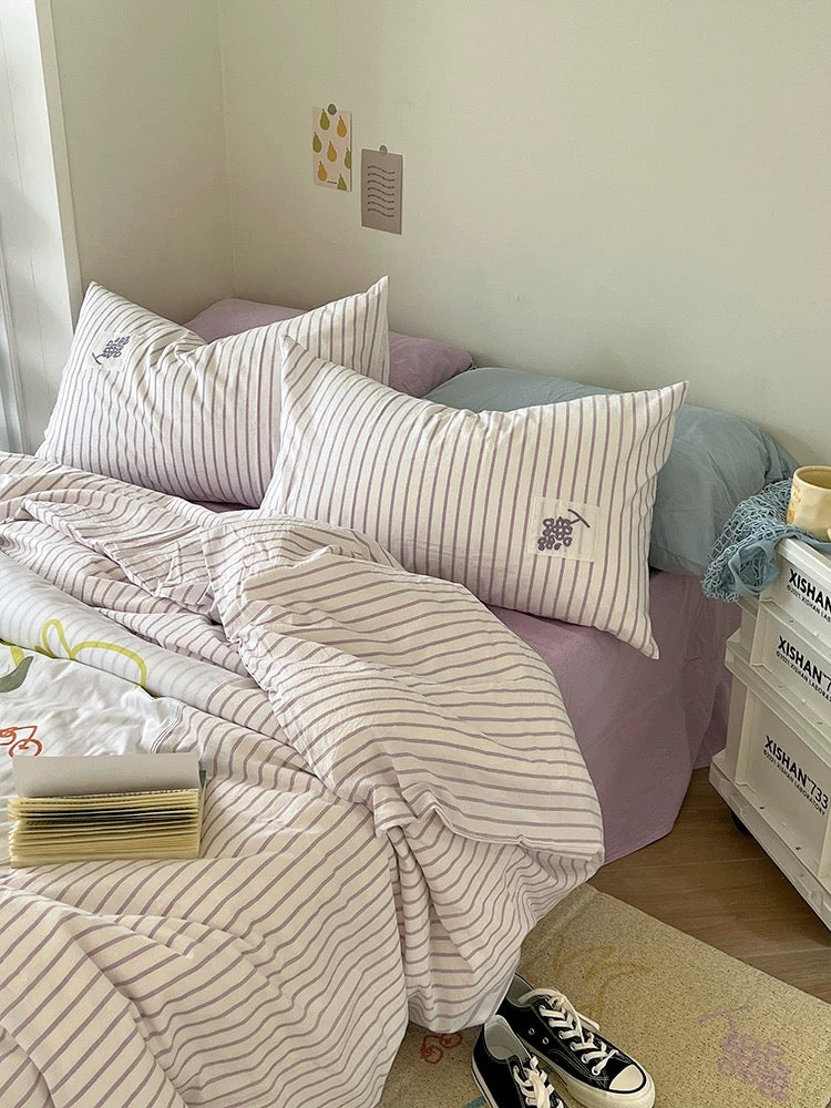 Striped duvet cover set with appliqued purple flower detail on pillow