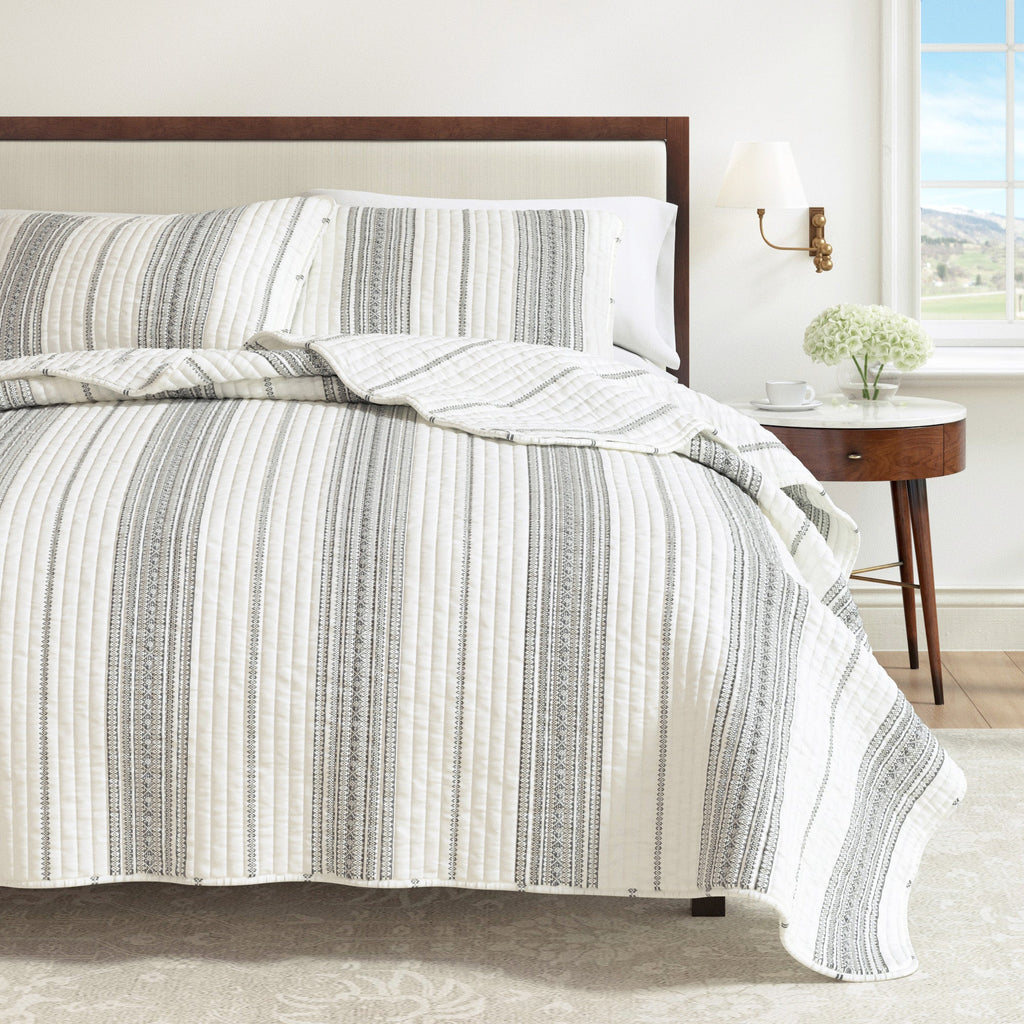 Stripe quilt and matching pillow shams with cream base and dark grey vertical bands