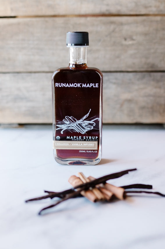 Maple syrup bottle with black cap and front label with vanilla and cinnamon sticks