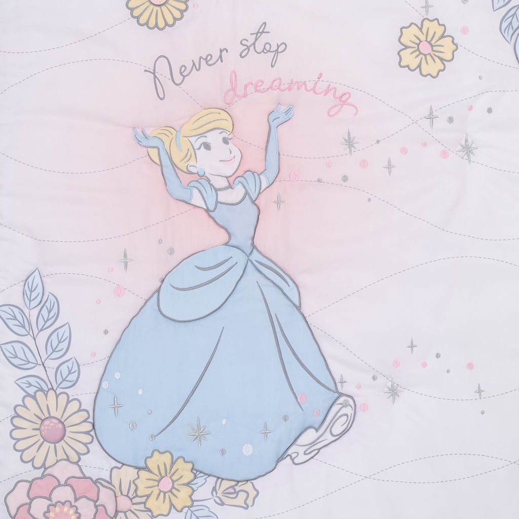 Close-up of light blue princess illustration and floral stars on pink comforter
