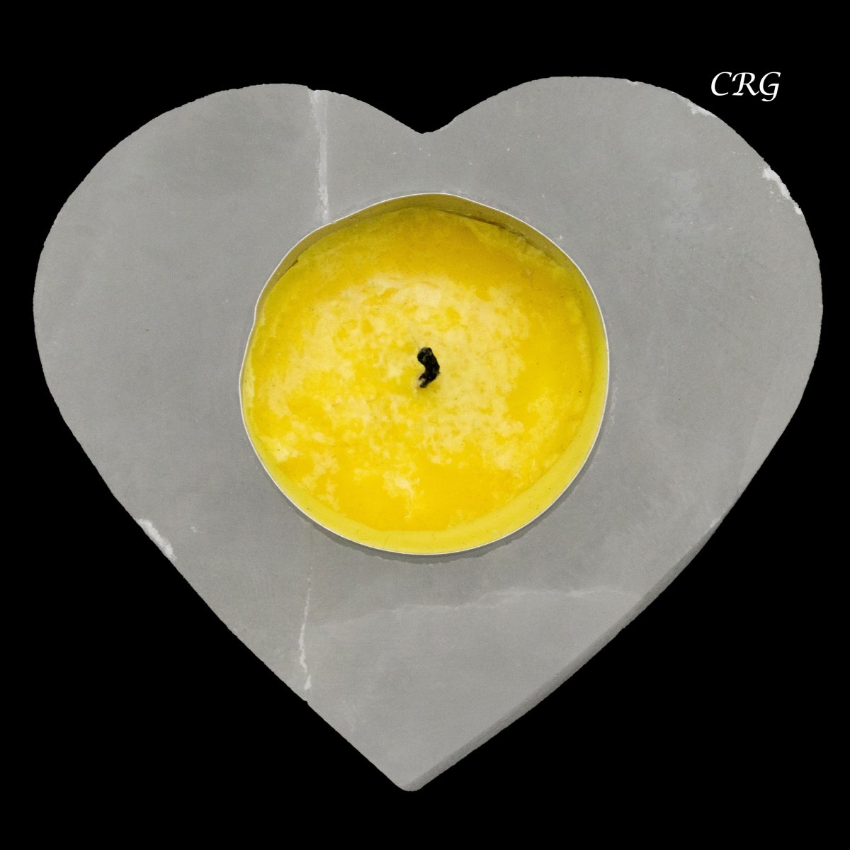 White heart selenite candle holder with yellow candle in center recess