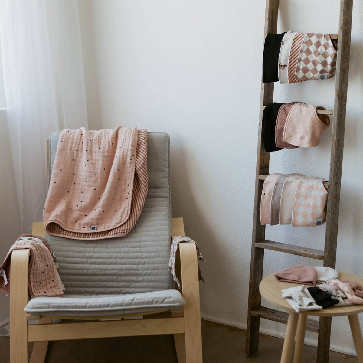 Blush muslin quilt draped over chair with dot print