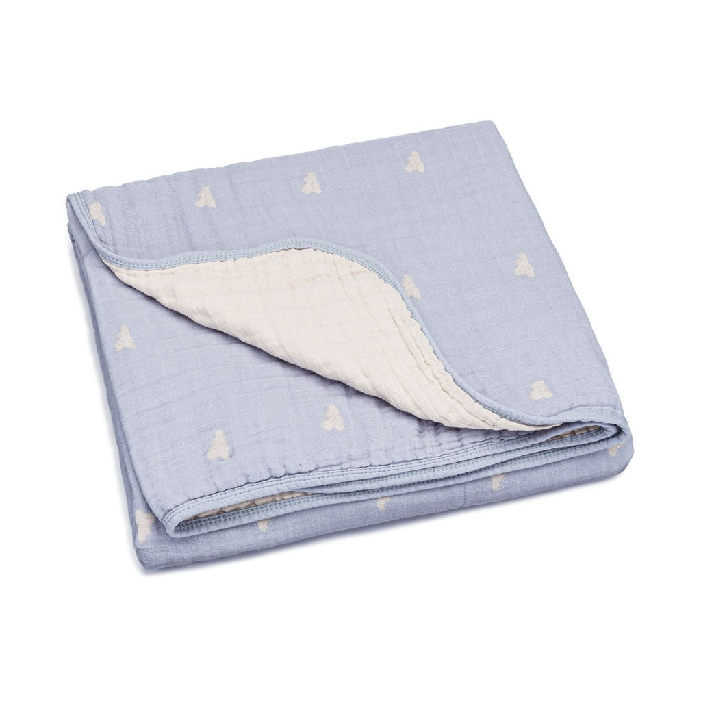 Light blue muslin quilt with small cloud motifs, folded with stitched border