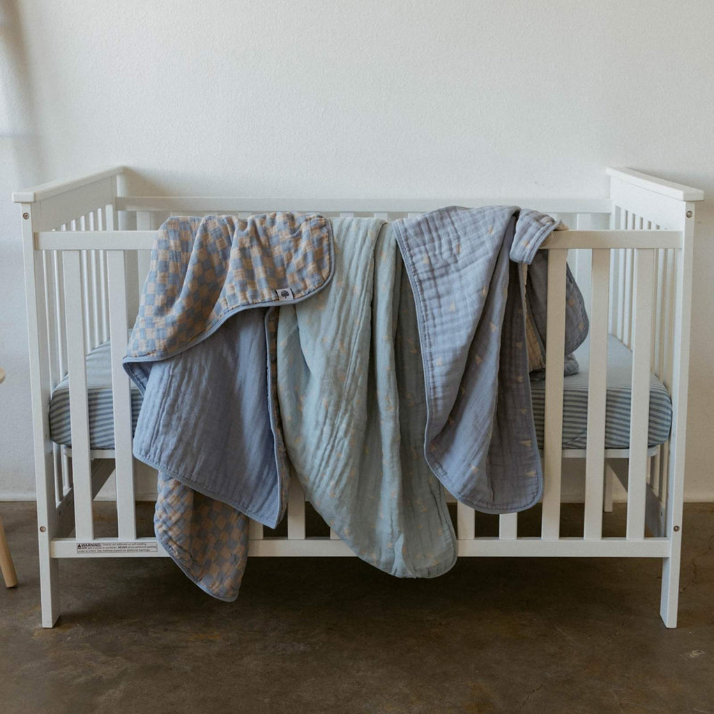 Light blue and gray plaid quilt on a crib
