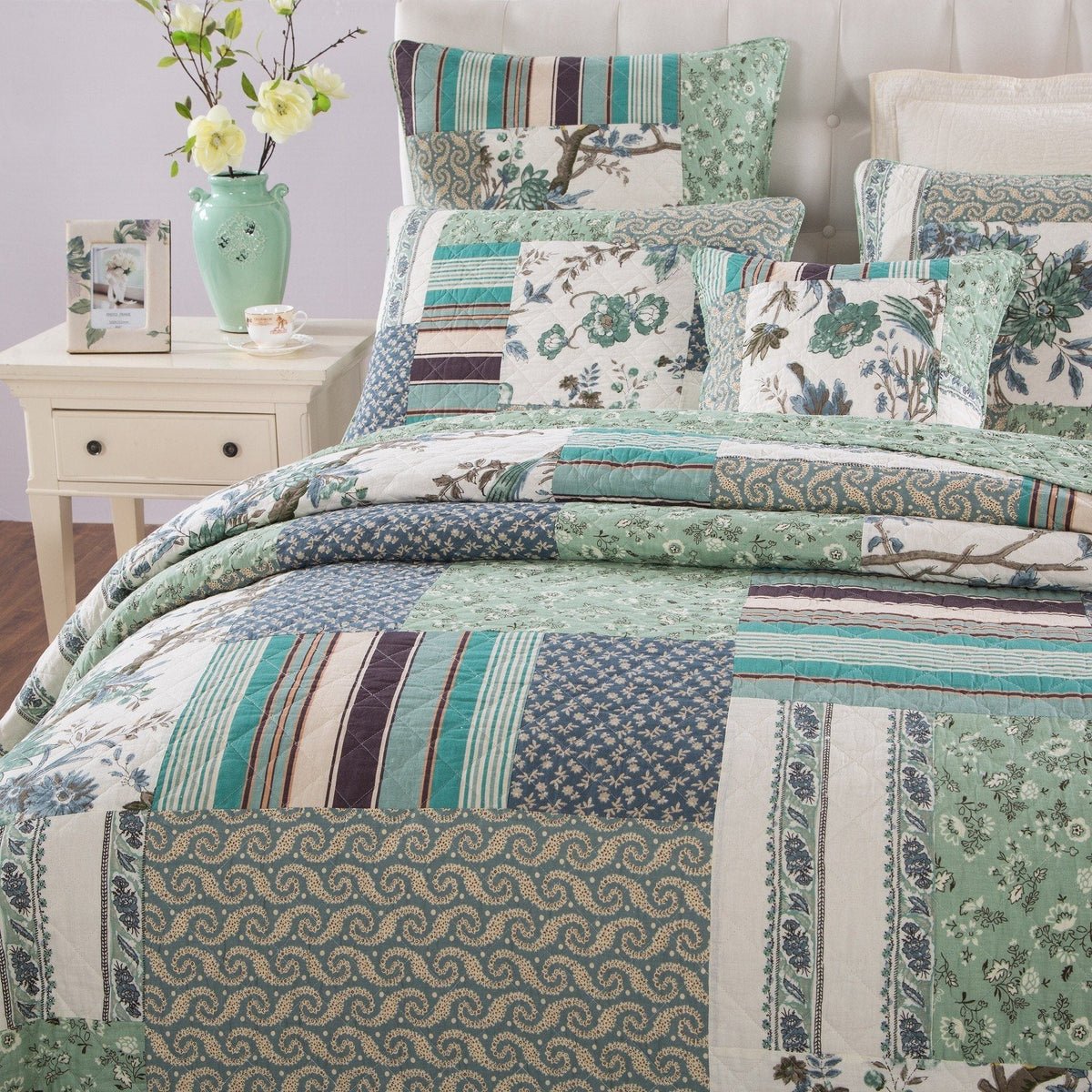 Quilted patchwork bedspread set with matching pillows in teal, green, and cream