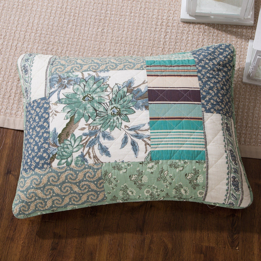 Patchwork quilted pillow with floral and stripe blocks in teal, blue, and cream